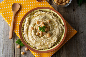Delicious homemade hummus pasta with olive oil and chick-peas. Wooden table. Healthy food. - obrazy, fototapety, plakaty