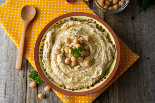 Delicious homemade hummus pasta with olive oil and chick-peas. Wooden table. Healthy food.