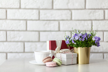 Gift boxes and flowers on white wall background