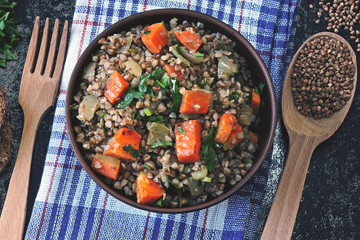 Buckwheat porridge with vegetables and herbs in a bowl. Flat lay. Healthy vegan food concept. Buckwheat diet