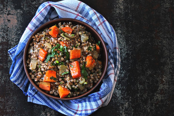 Buckwheat porridge with vegetables and herbs in a bowl. Flat lay. Healthy vegan food concept. Buckwheat diet