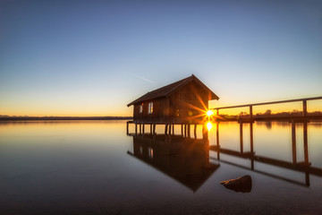 Fototapeta na wymiar Fischerhütte am See im Sonnenuntergang