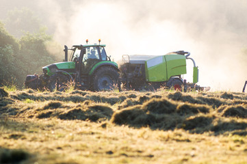 Fototapeta premium Rolnik z ciągnikiem w polu