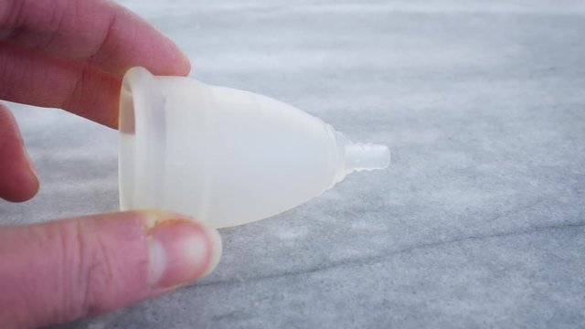 Replacing tampons with a silicone diva cup and copy space for text. Conceptual shot of choosing sustainable, eco-friendly feminine hygiene products over disposable ones that will end up in a landfill.