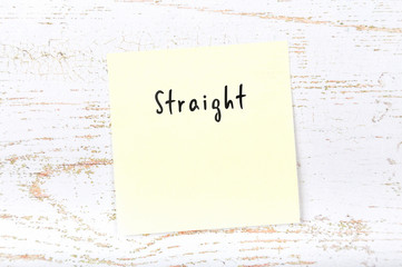 Yellow sticky note with handwritten word straight