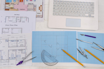Paper for drafting and tools with laptop on desk