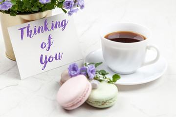 Thinking of You postcard note on white marble table