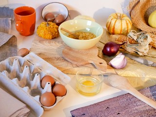Eggs, pumpkins, onions, vegetables, sea salt on a light table, top view, home cooking ingredients, shades of yellow