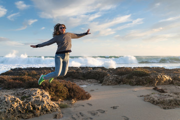 girl jumping on the beach at sunset