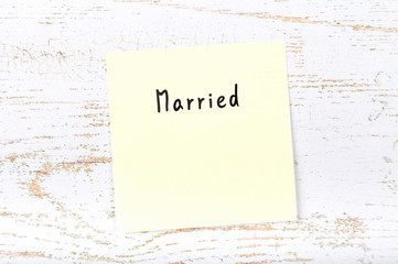 Yellow sticky note with handwritten word married