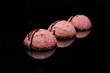 Obraz na płótnie Canvas Cashew souffle cakes with beetroot powder on a pillow of crushed nuts and dried figs. Vegan, dietary raw sweets. Place for text on top.
