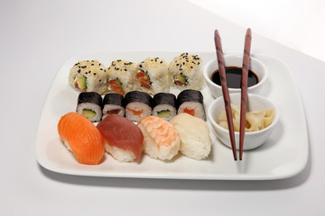 close up of sashimi sushi set with chopsticks and soy - sushi roll with salmon and sushi roll with smoked eel