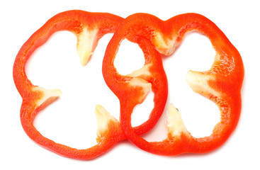 cut slices of red sweet bell pepper isolated on white background top view