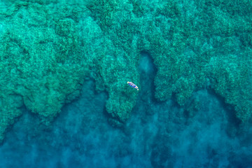 aerial of paddler on reef