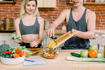 Man and woman in the kitchen at home. They prepare a tasty and healthy breakfast. They cook...
