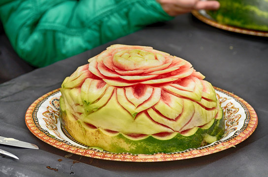 carving sculptures from watermelons.Artists create works of art.