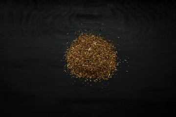 Close-up image of dry savory on black wood background, view above