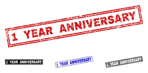 Grunge 1 YEAR ANNIVERSARY rectangle stamp seals isolated on a white background. Rectangular seals with distress texture in red, blue, black and grey colors.