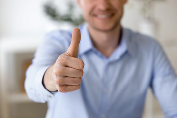 Close up businessman smiling showing thumbs up