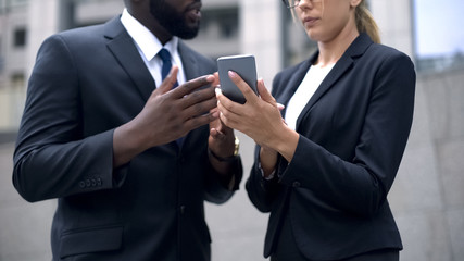 Business people discussing online organizer in smartphone, work and day planning