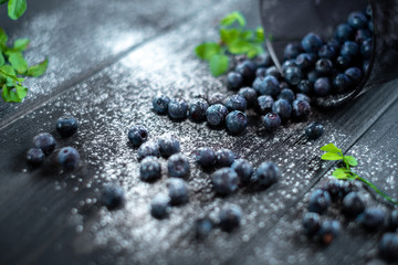 Fresh blueberries in a glass on a dark wooden background, Rustic style. Healthy food or nutrition. Macro