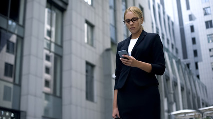 Sad business lady looking at phone, news about failed contract and lost money