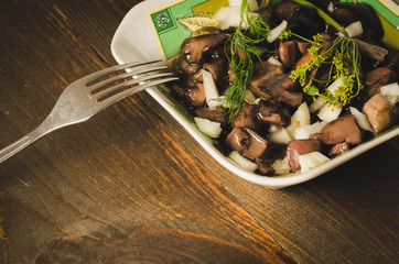 mushrooms in a plate on a wooden table, Selective focus. Rustic style