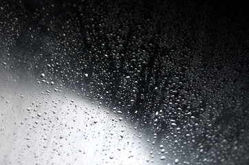 Regentropfen auf grauem Metall