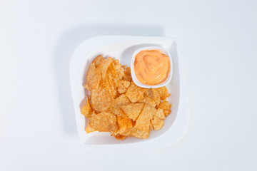 Corn chips in a white ceramic dish with cheesy dip