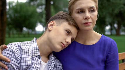 Naklejka na ściany i meble Caring mother supporting teen boy in time of trouble, bullying problem in school