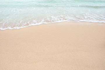 Naklejka na ściany i meble Soft wave of sea on empty sandy beach Background with copy space
