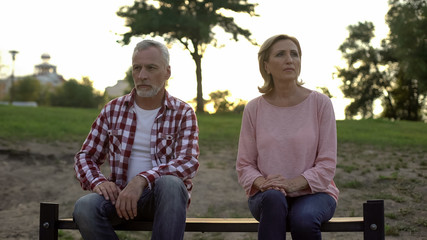 Fototapeta premium Offended elderly couple sitting on bench and thinking about divorce, relations