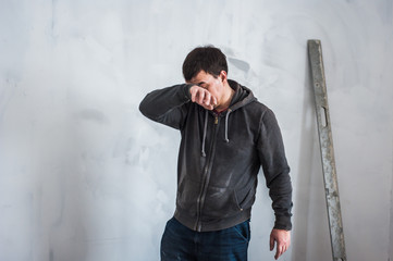 Tired worker wipes sweat from face