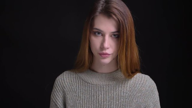 Closeup portrait of young beautiful caucasian female being upset and depressed looking straight at camera