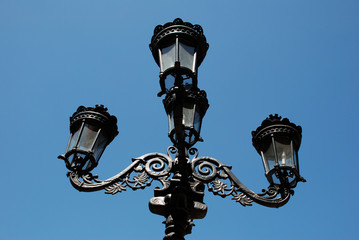 Fototapeta na wymiar Antique streetlamp in Savannah Georgia against a striking blue sky