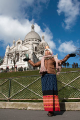 Femme ouvrant les bras devant la basilique Montmartre à Paris