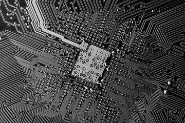 Close up photo of black and white pcb printecd circuit board electric paths