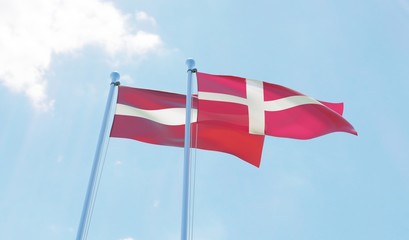 Latvia and Denmark, two flags waving against blue sky. 3d image