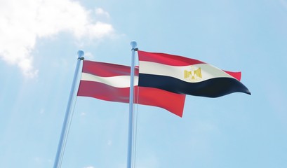 Latvia and Egypt, two flags waving against blue sky. 3d image