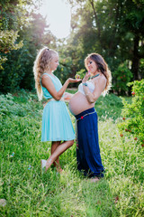 pregnant mother and daughter happy in the field