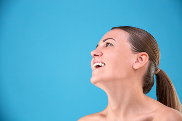 Beauty portrait young attractive half naked woman with perfect skin laughing and looking at camera isolated over blue background Skin Care Concept.