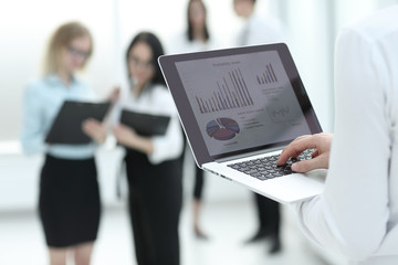 businessman uses laptop to check financial data