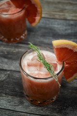 Grapefruit and rosemary gin tonic  cocktail, refreshing drink with ice on wooden background