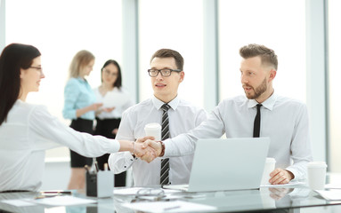 handshake of business partners at the table in the business center