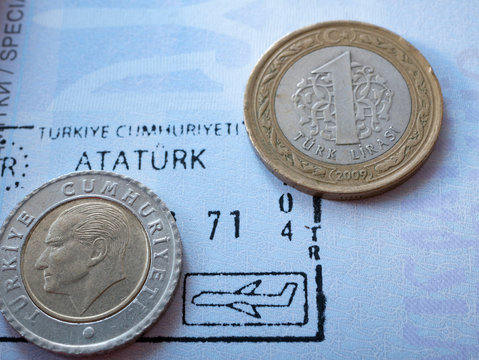 turkish currency money few coins liras on airport arrival stamp at international foreign passport. Ataturk portrait and inscription visible. macro close-up image