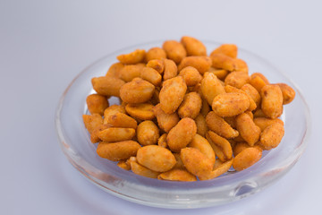 Spicy peanuts on transparent plate