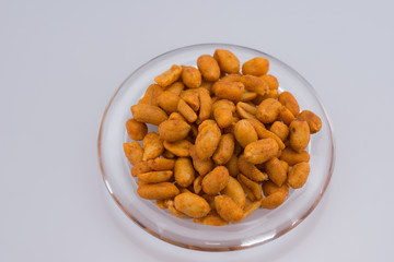 Spicy peanuts on transparent plate