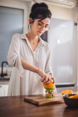 Woman making orange juice in the kitchen