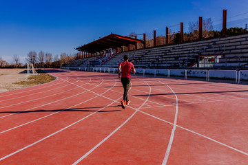 Fototapeta premium young athlete man running in the lanes. Daylight. Sports concept