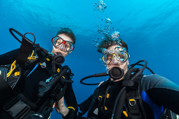 Young woman and man scuba divers making selfie.